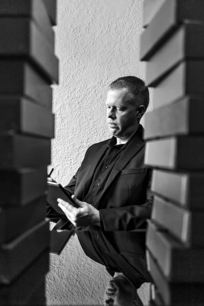 Corporate professional analyzing paperwork between brick walls.