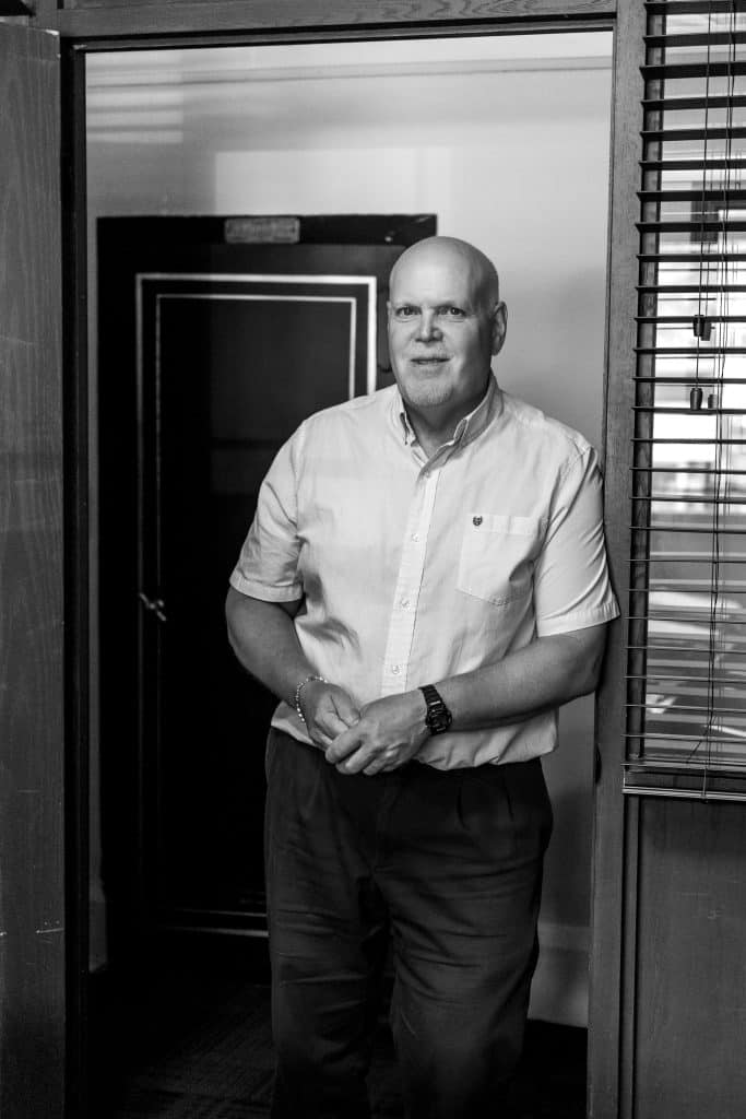 Professional man standing in office doorway at Strike and Phillips.