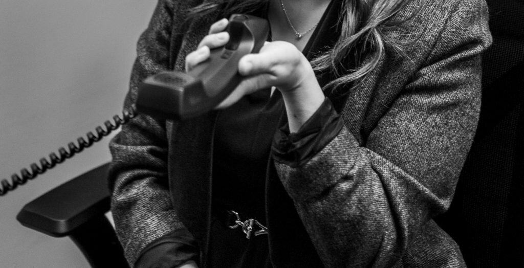 Woman holding a phone during a refinance consultation at Strike and Phillips.