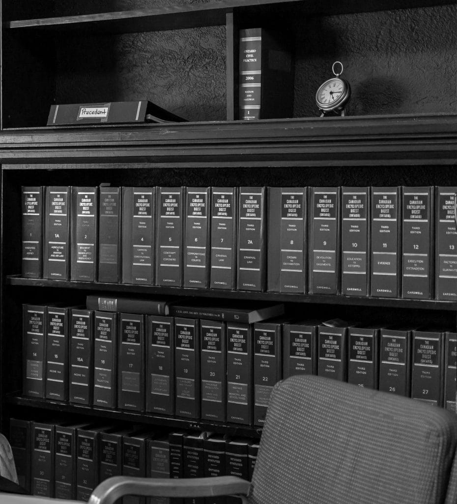 Law office bookshelf with legal books and a clock at Strike and Phillips.