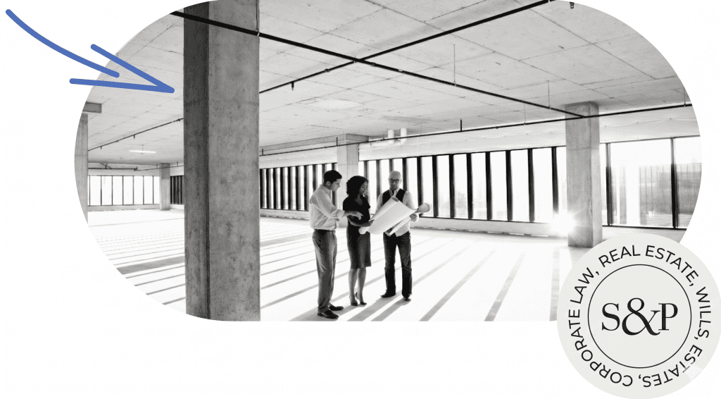 Interior of commercial leasing space with large windows and professionals discussing plans.
